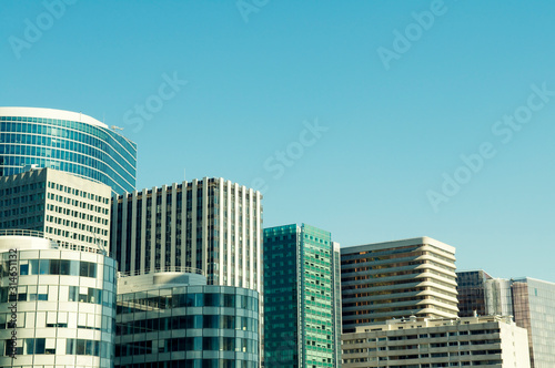 Abstract city skyline view of anonymous office towers under soft blue sky