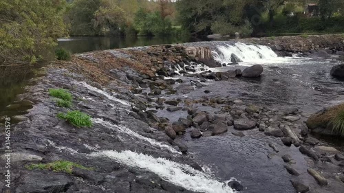 Static shot, of the Ponte Maceira rapids, at the Tambre river, on a overcast day, in Santigo de Compostela, A Coruna, Spain photo