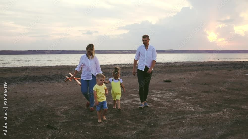 Happy family spends time on sea sand beach, slow motion Happy family spends time on sea sand beach, slow motion