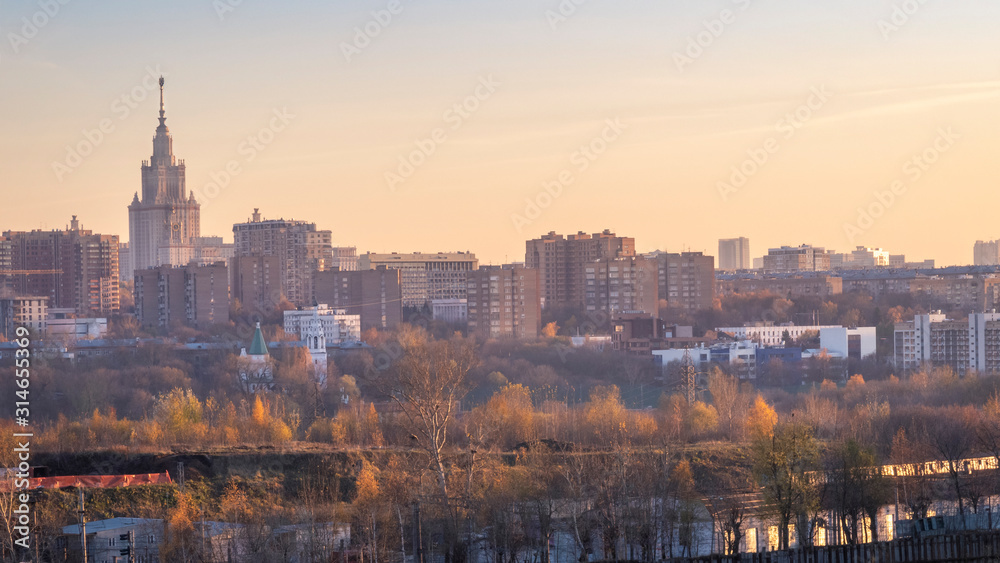 Moscow cityscape with State University and common buildings at autumn sunset.