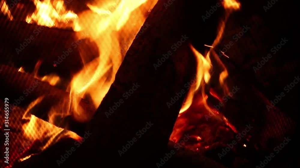 Flames and embers burning brightly in a wood fire at night Flames and embers burning brightly in a wood fire at night