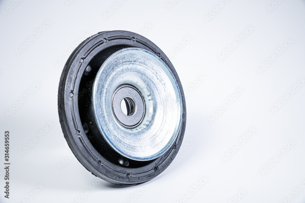 New thrust bearing of front suspension strut of a car on a gray background. The concept of new spare parts and replacement parts in service centers New thrust bearing of front suspension strut of a car on a gray background. The concept of new spare parts and replacement parts in service centers