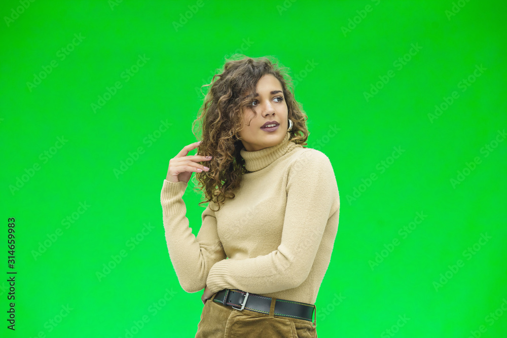 Alluring sensual young lady rolling a lock of her curly hair around her finger, smiling, looking happy and coquettish. Alluring sensual young lady rolling a lock of her curly hair around her finger, smiling, looking happy and coquettish.