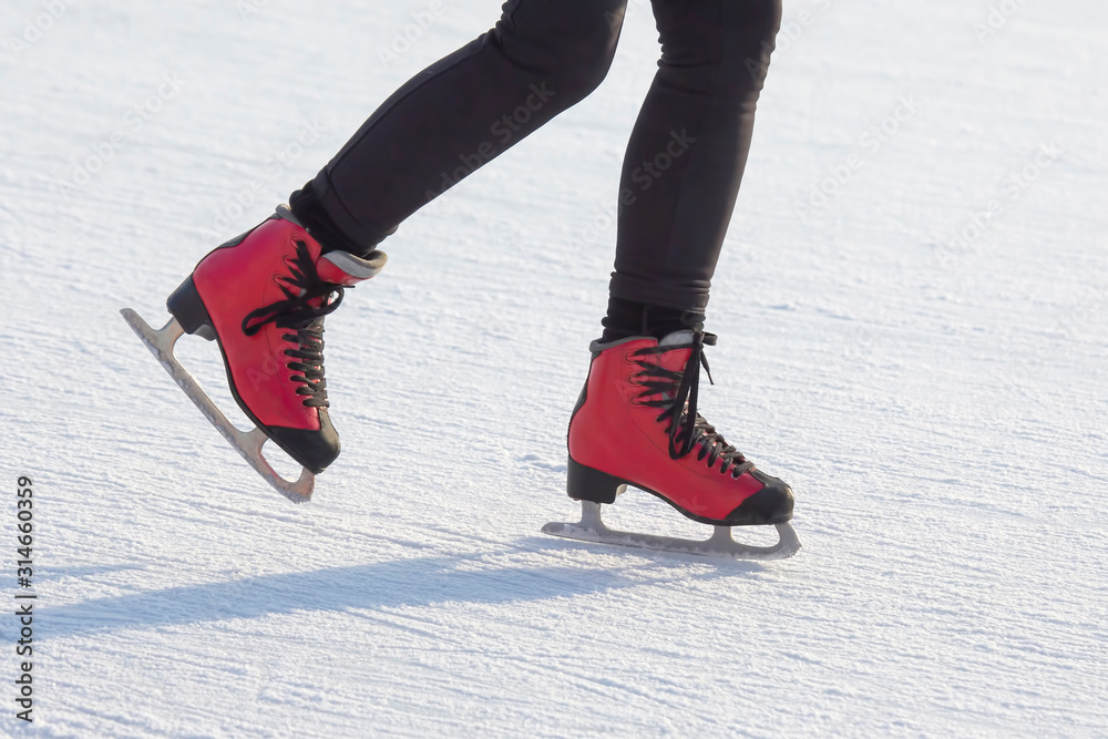 feet in red skates on an ice rink. Hobbies and sports. Vacations and winter activities. feet in red skates on an ice rink. Hobbies and sports. Vacations and winter activities.