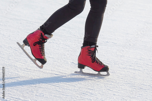feet in red skates on an ice rink. Hobbies and sports. Vacations and winter activities.