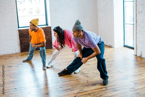 young woman and stylish multicultural men in dance studio © LIGHTFIELD STUDIOS