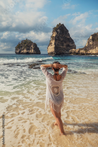 Woman walking on a beach at Diamond Bay, Nusa Penida island, Indonesia