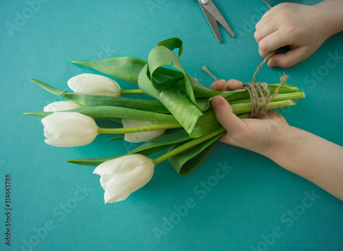 Fototapeta Naklejka Na Ścianę i Meble -  Hands of a child make a bouquet of tulips.
