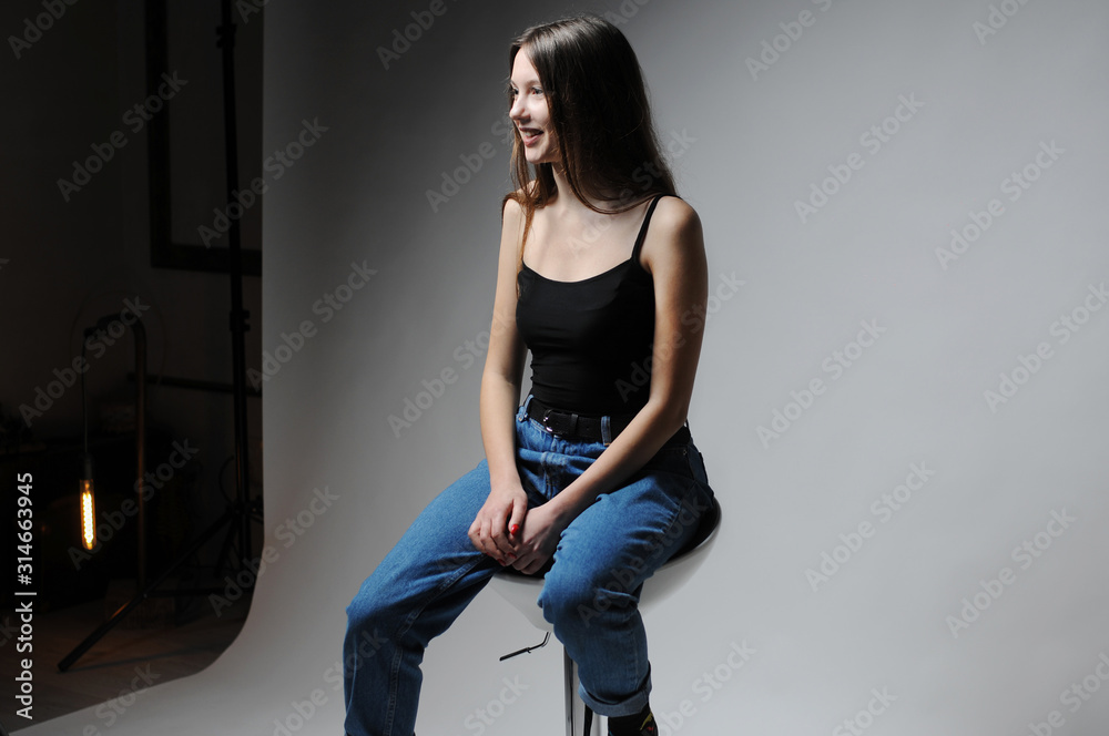 Portrait of beautiful female face with natural skin.Girl sitting on a chair.