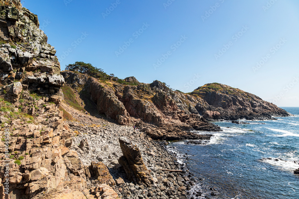 Rock formations on shore against clear sky
