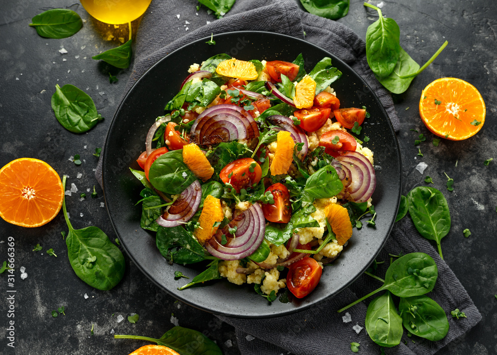 Vegetable Millet salad with red onion, cherry tomatoes, spinach, tangerine and clementine dressing. healthy food