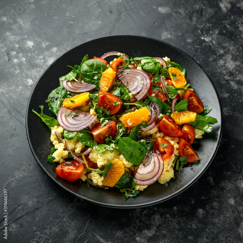 Vegetable Millet salad with red onion, cherry tomatoes, spinach, tangerine and clementine dressing. healthy food