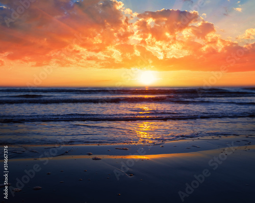 dramatic sunset over the sandy sea beach, dramatic outdoor background © Yuriy Kulik