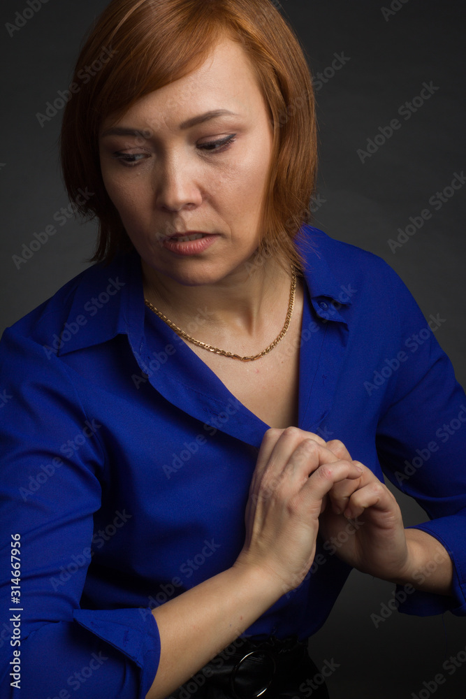Studio portrait of an attractive woman on a dark background with a short haircut Studio portrait of an attractive woman on a dark background with a short haircut