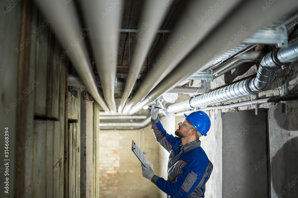 Male Worker Inspecting Pipes Male Worker Inspecting Pipes