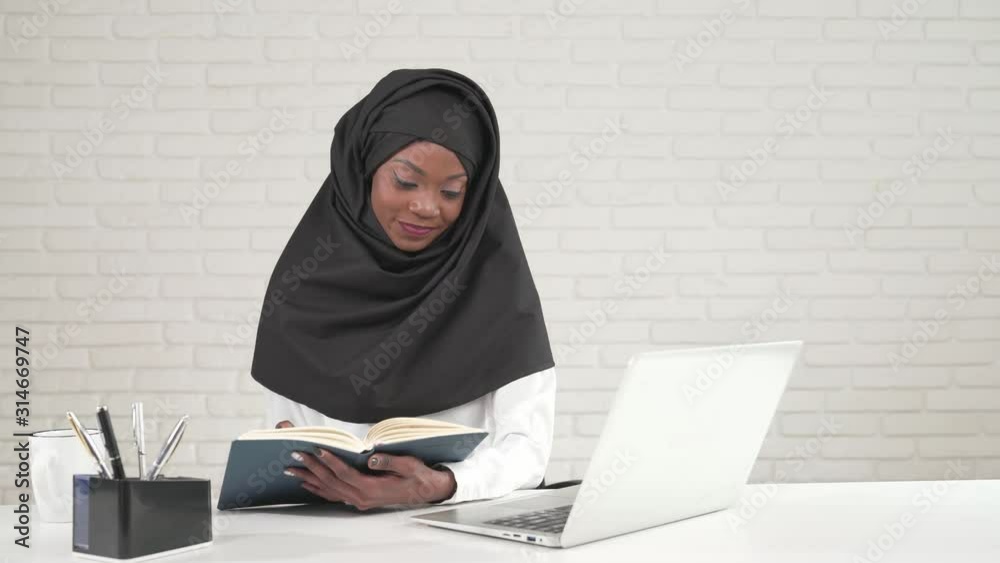 African woman turning pages in notebook. African woman turning pages in notebook.
