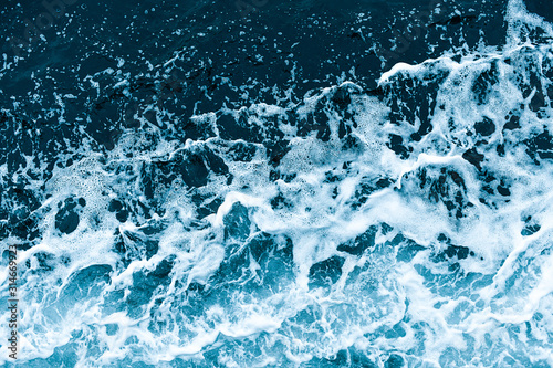 Background shot of aqua sea water waves surface. Blue ocean water and foam aerial view.
