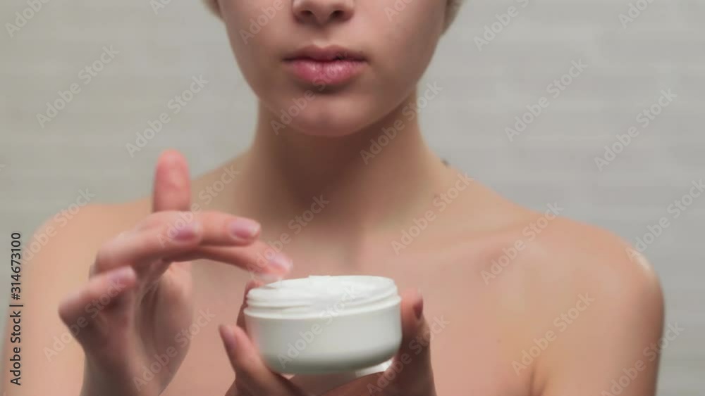 Incognito woman in towel showing cream. Incognito woman in towel showing cream.