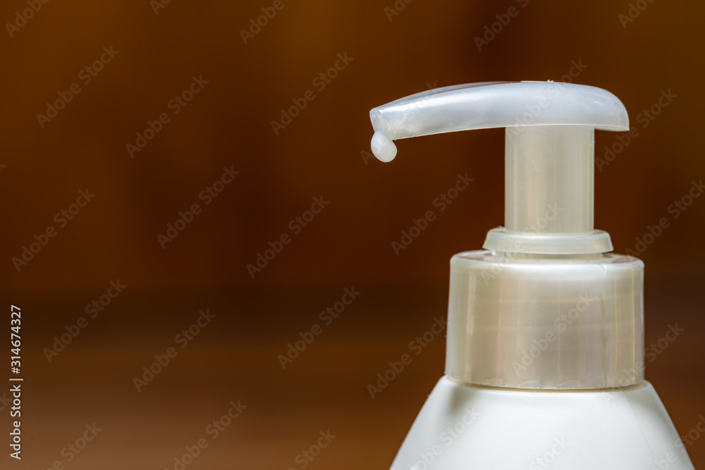 Lotion pump dispenser head isolated on wooden background Lotion pump dispenser head isolated on wooden background