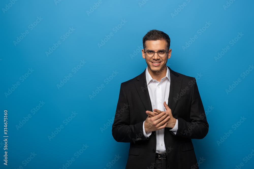 Smiling businessman looking at camera on blue background Smiling businessman looking at camera on blue background