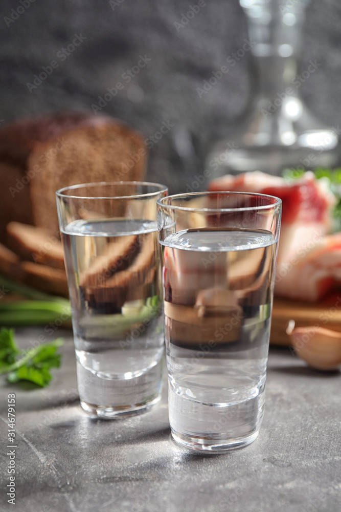 Cold Russian vodka with snacks on grey table, closeup Cold Russian vodka with snacks on grey table, closeup