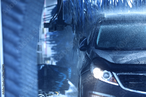 Modern auto undergoing cleaning at car wash photo