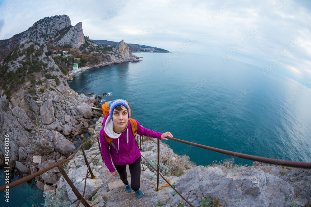 A woman climbs the stairs to the top of the mountain.