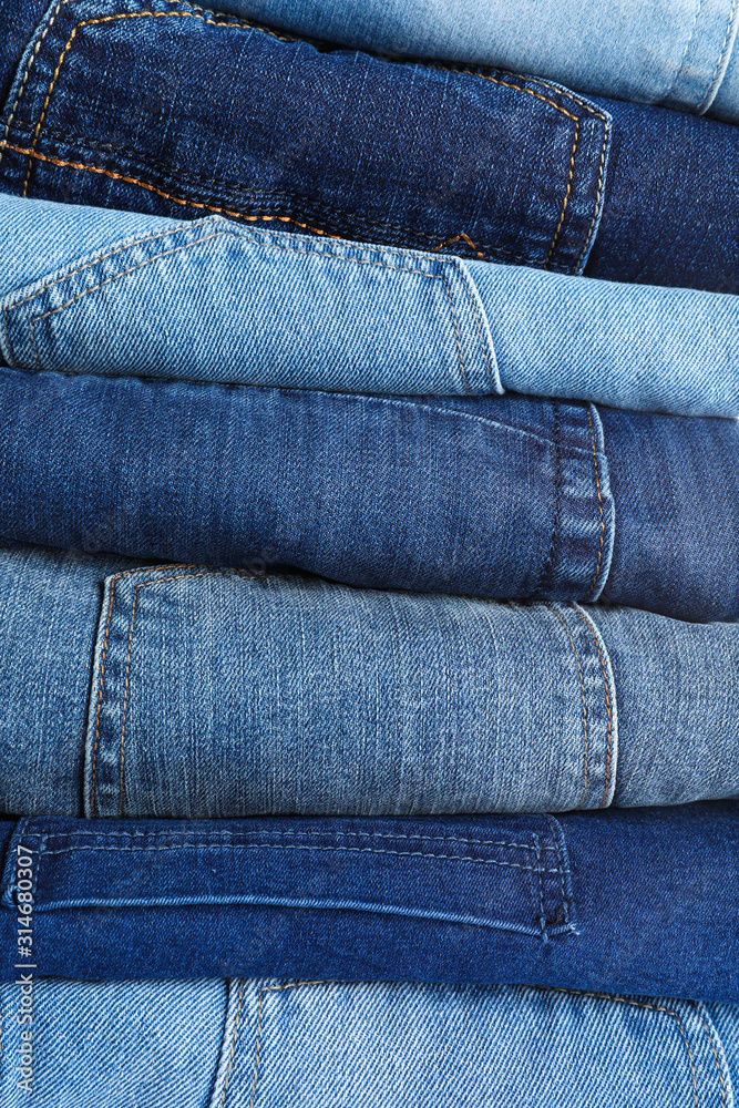 Stack of different jeans as background, closeup Stack of different jeans as background, closeup