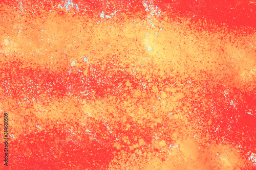 Red wallpaper with yellow paint stains and blue spots. Colorful orange background for your design. Bright texture of abstract backdrop. Horizontal orientation.
