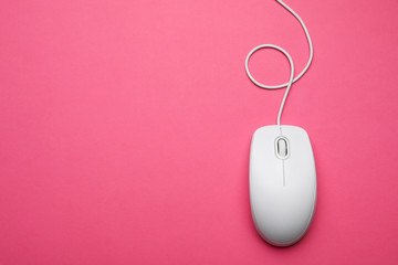 Wired computer mouse on pink background, top view. Space for text