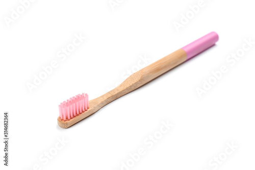 Bamboo toothbrush with pink bristle isolated on white