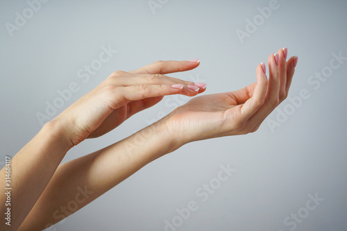 Spa and Manicure concept. Beautiful hands of a young girl with beautiful manicure on a gray background.