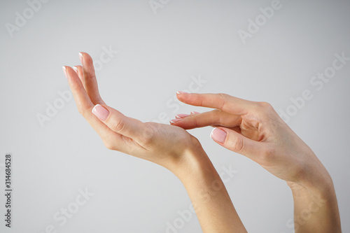 Spa and Manicure concept. Beautiful hands of a young girl with beautiful manicure on a gray background