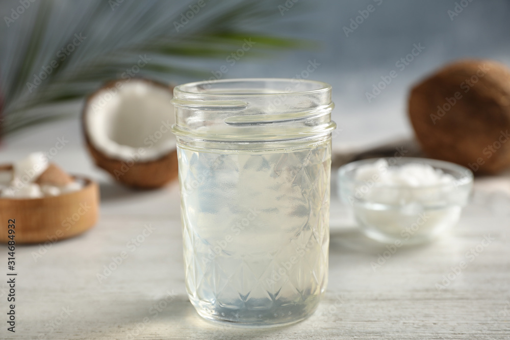 Coconut oil on white wooden table, closeup Coconut oil on white wooden table, closeup