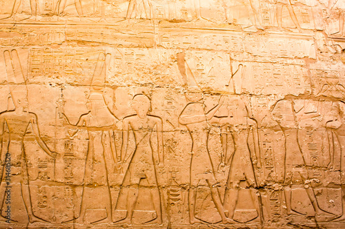 Karnak temple complex in Luxor, Egypt. Ancient bas relief with hieroglyphs on wall, pharaohs and gods.