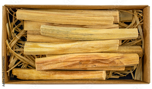 Palo Santo sticks (meaning Holy Wood) in a cardboard gift box, close-up. Isolated. Bursera Graveolens. Traditional energy cleansing wood. photo