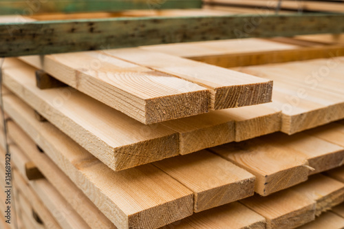 Piles of wooden boards in the sawmill, planking. Warehouse for sawing boards on a sawmill outdoors. Wood timber stack of wooden blanks construction material. Industry. photo