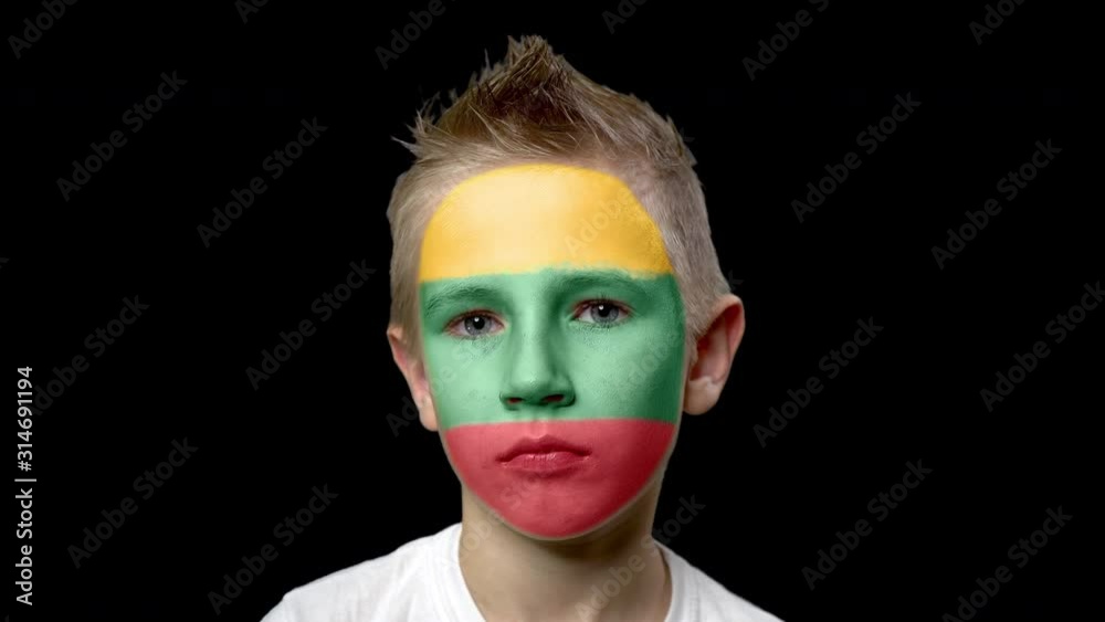 Sad fan of the football team of Lithuania. A child with a face painted in national colors. Unhappy boy with sad eyes. Fiasco of your favorite team. Disappointment. Sadness. Experience. Failure. Sad fan of the football team of Lithuania. A child with a face painted in national colors. Unhappy boy with sad eyes. Fiasco of your favorite team. Disappointment. Sadness. Experience. Failure.