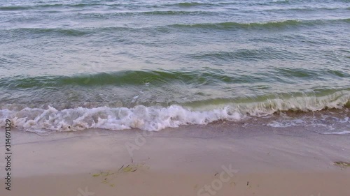 waves of the Black Sea splashing around on a sandy shore on a summer day, the village of Zhelezny Port Ukraine, slow motion photo