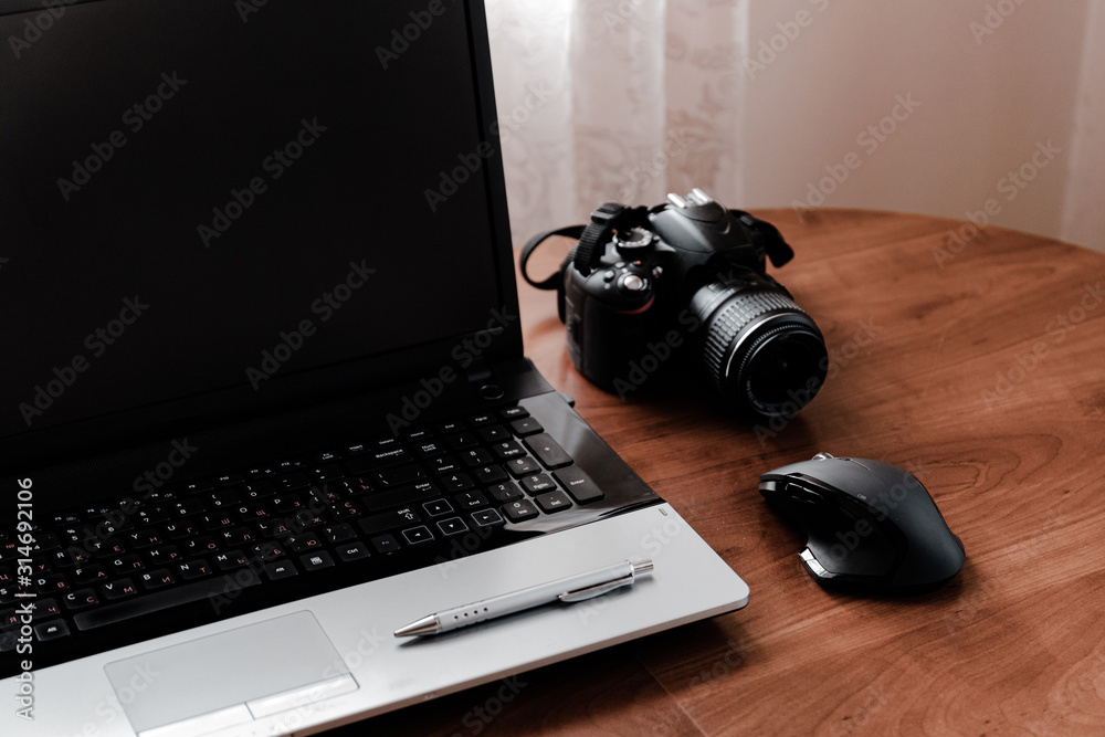 Working space of Photographer or Designer which including of dslr camera lens and wireless mouse on wood desk. Smart Phone, Smart Watch, computer and mouse, tablet for professionals photographer.