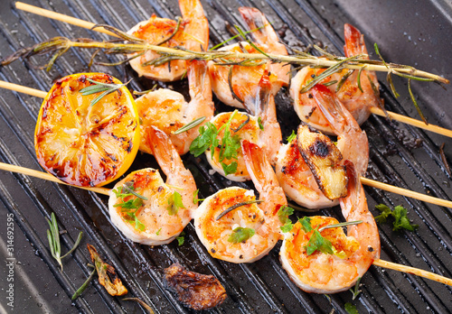 grilled shrimp on skewers. Grilled seafood on skewers with spices, herbs and lemon. delicious prawn. Grill. The iron grill. close up