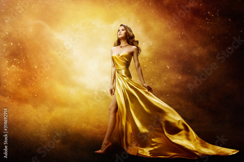 Fototapeta Woman in Gold Dress Looking to Space Stars, Beautiful Fashion Model on Golden Ni