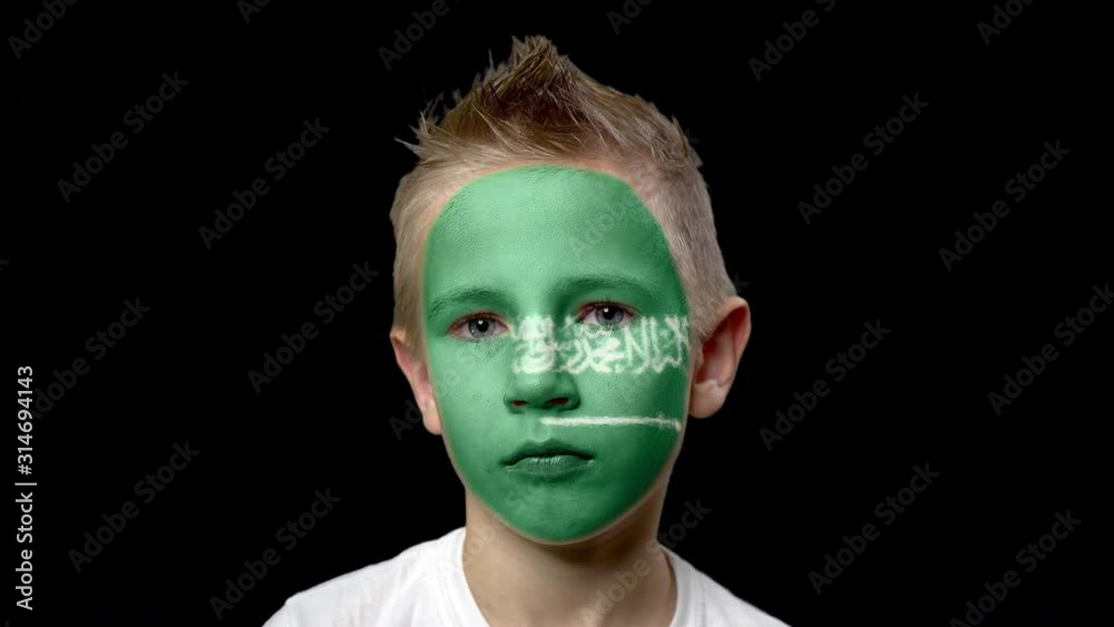 Sad fan of the football team of Saudi Arabia. A child with a face painted in national colors. Unhappy boy with sad eyes. Fiasco of your favorite team. Disappointment. Sadness. Experience. Failure. Sad fan of the football team of Saudi Arabia. A child with a face painted in national colors. Unhappy boy with sad eyes. Fiasco of your favorite team. Disappointment. Sadness. Experience. Failure.