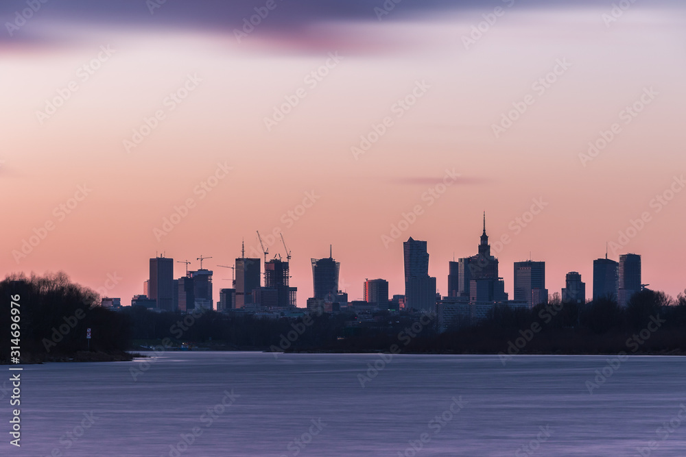 Fototapeta premium Warsaw urbanscape with skyscrapers during colorful twilight.