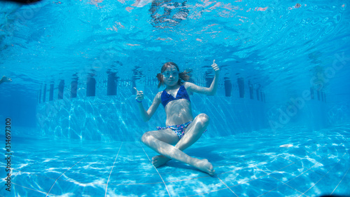 Underwater Young Girl Fun in the Swimming Pool with Goggles. summer concept. Summer Vacation Fun