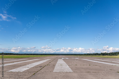 The runway of a rural small airfield against a blue sky photo