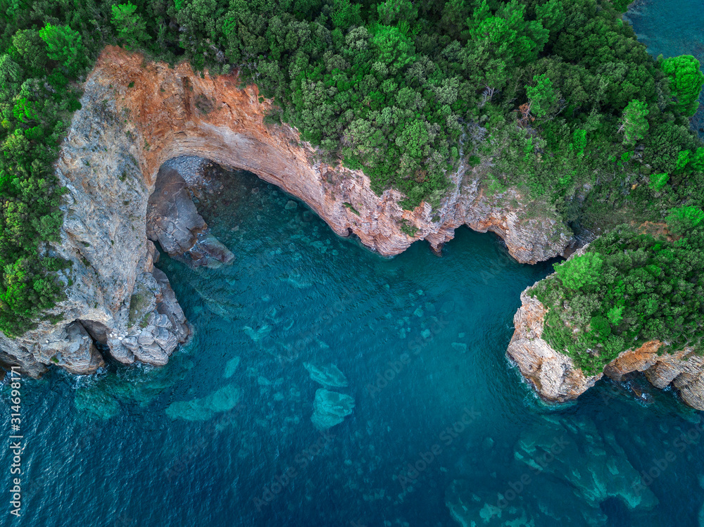 Aerial view of a steep cliff, unspoiled nature of the Montenegro coast. Sea caves and inlets alternate on the Mediterranean coast