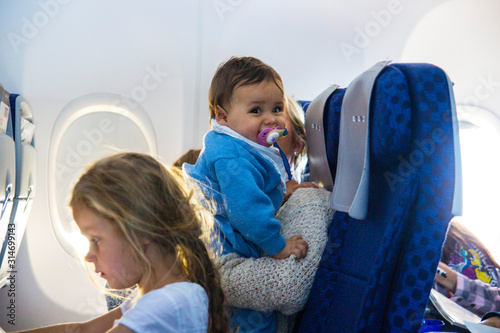 Kleinkind - Mädchen mit Schnuller im Flugzeug photo