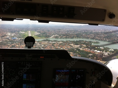 First-person view of aircraft at landing at Belo Horizonte airport with lagoon and Pampulha architectural complex in the background,