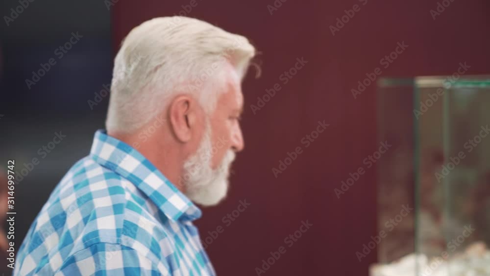 Side view of mature man choosing jewelry for his wife Side view of mature man choosing jewelry for his wife